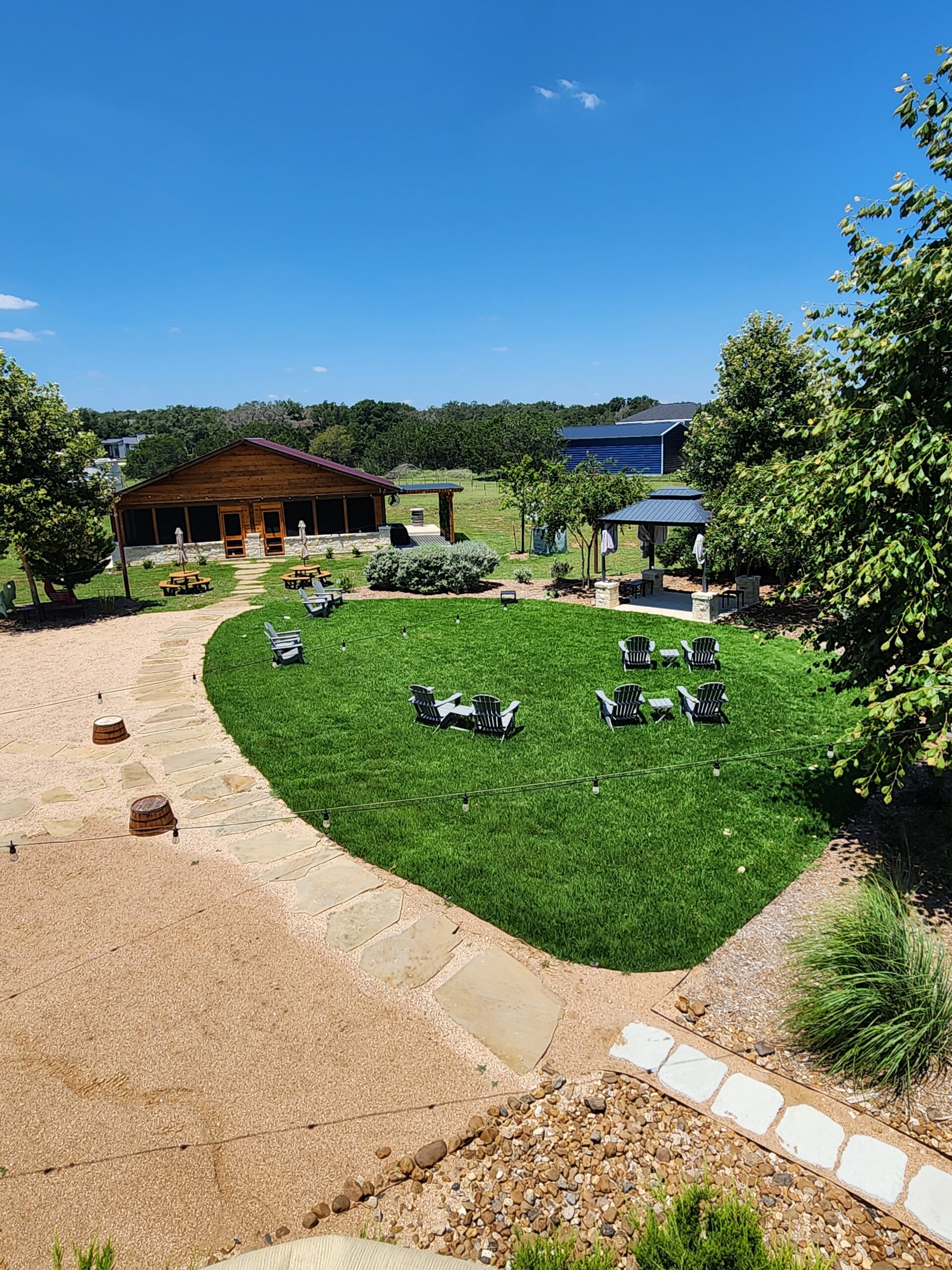 Scenic outdoor area with green lawn, chairs, and wooden cabin